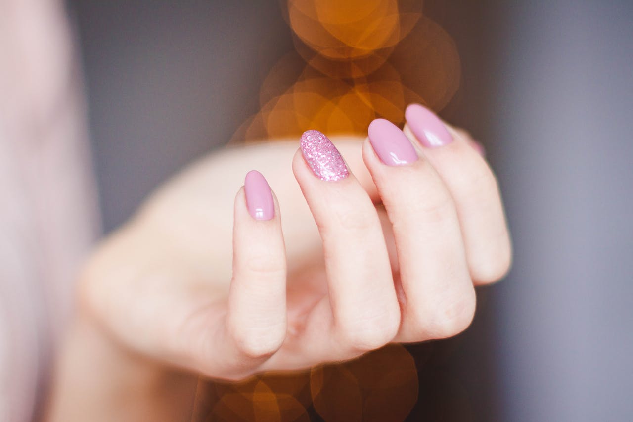 Kobieta precyzyjnie wykonuje manicure, nadając swoim paznokciom piękno i elegancję